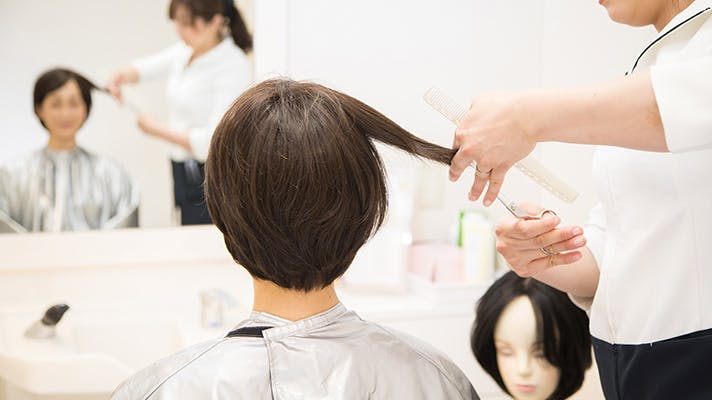 髪を切られている女性