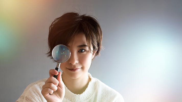 虫眼鏡を覗く女性