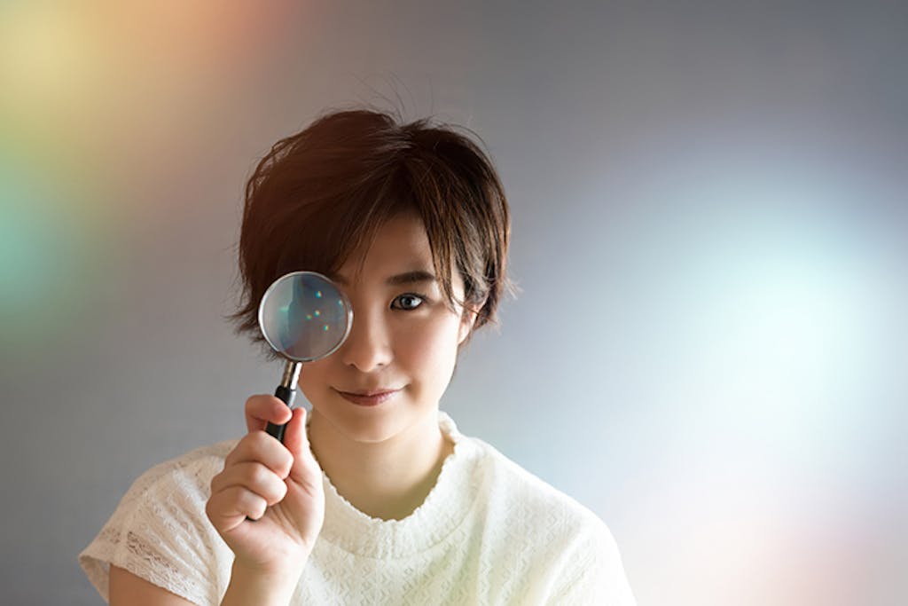 虫眼鏡を覗く女性