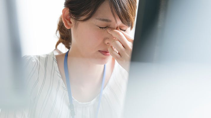 目頭をおさえる女性