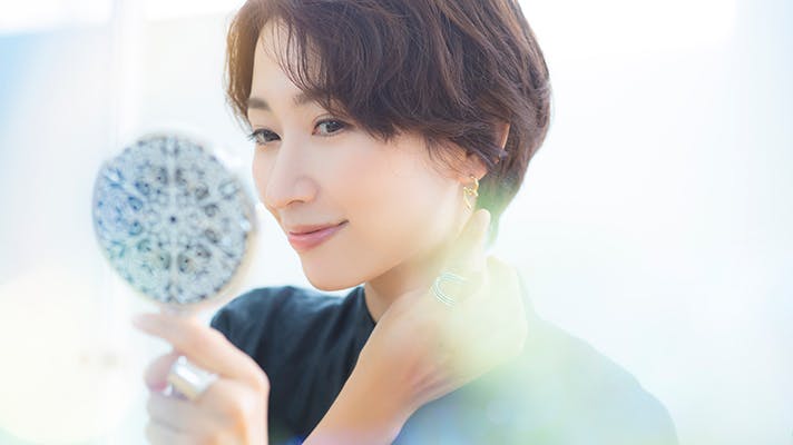 手鏡で自分を見る女性