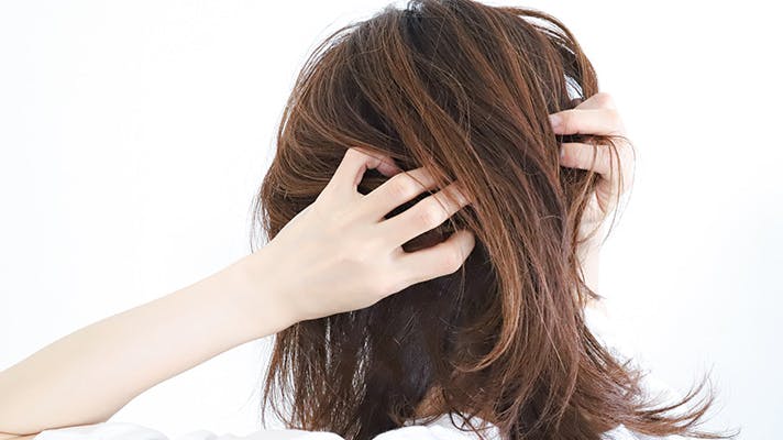 両手で頭を抱える女性
