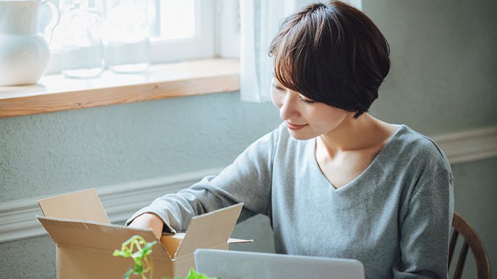 段ボールの中身を確認する女性