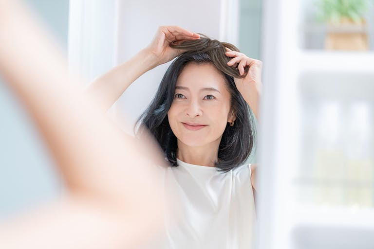 ウィッグを付けようとしている女性