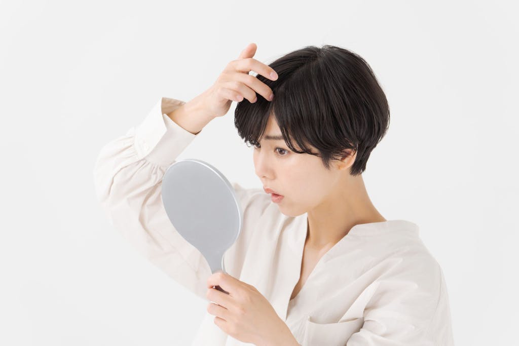 鏡を見て髪型を確認する女性