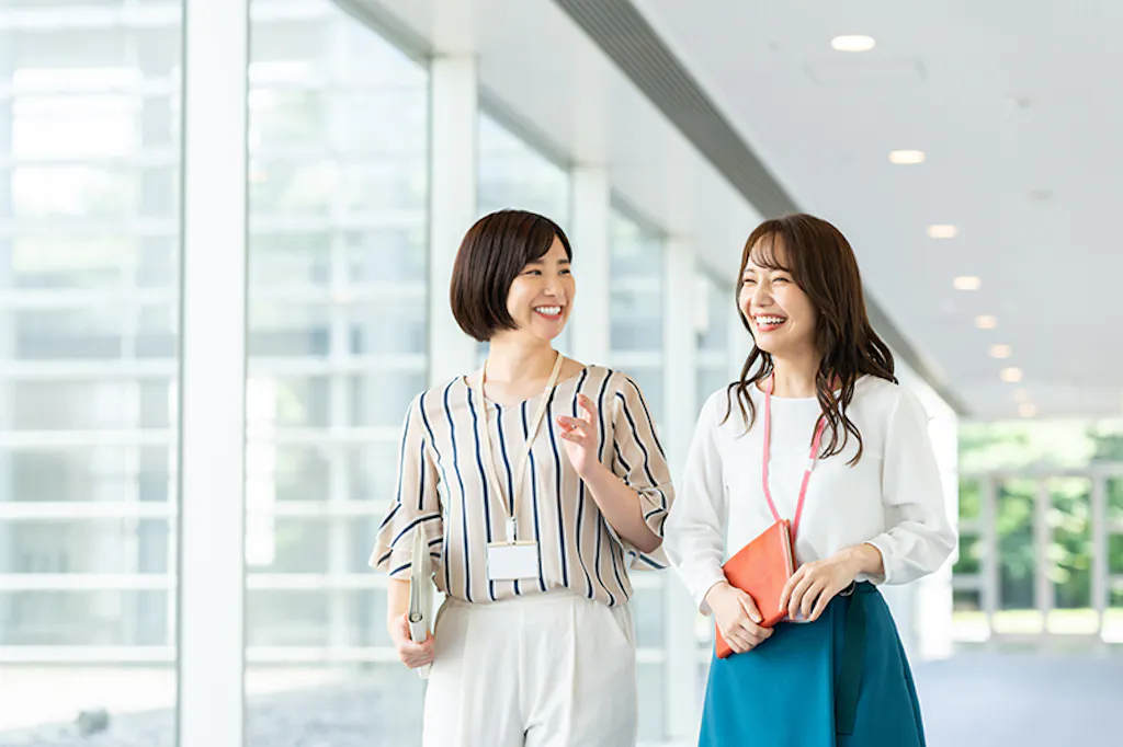 女性二人が笑いながら歩く様子
