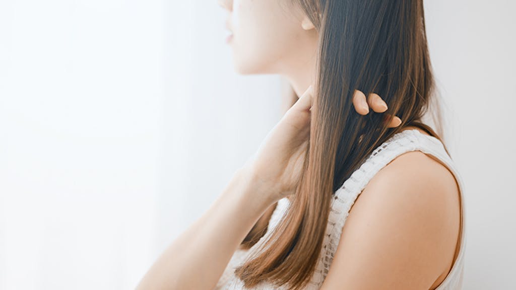 手で髪を梳かす女性