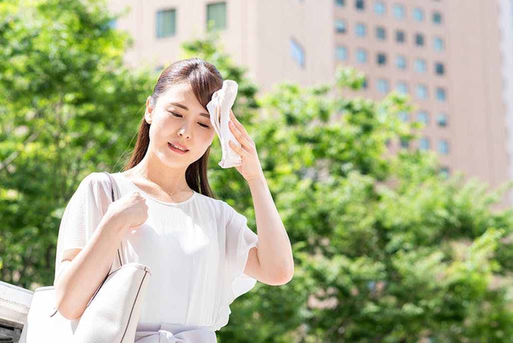 ハンカチで汗を拭く女性