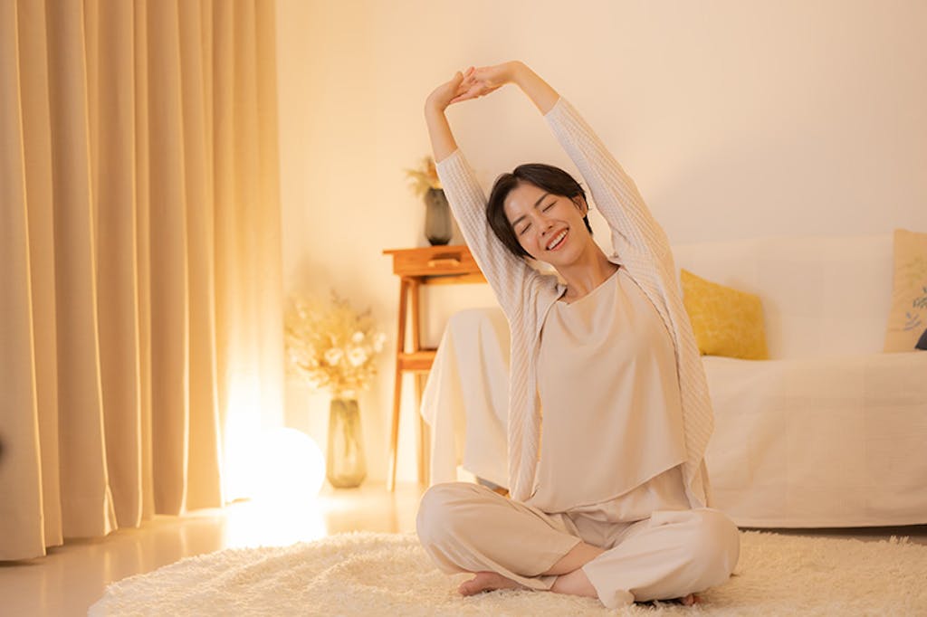 部屋でストレッチをする女性