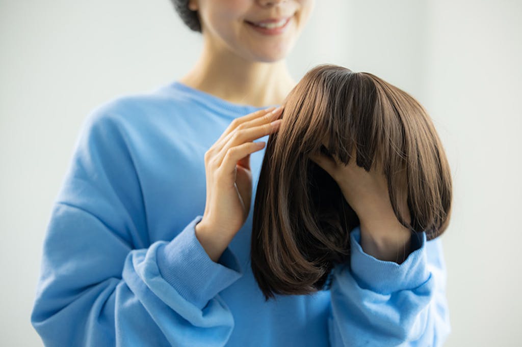 ウィッグを手に取って触る様子